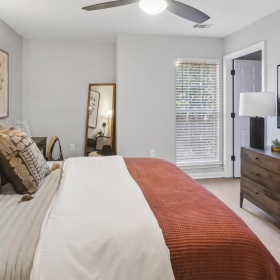 Relax and recharge in beautiful and spacious bedrooms a bedroom with a bed and a fan
